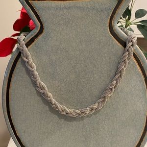 Cute Necklace Silver-tone braided, lightweight. Lays flat. Looks good.